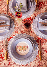 Casa by Josephine Jenno tablecloth featuring a vibrant red floral design with matching plates and cutlery