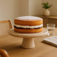 Orsina Cake Stand showcasing a sponge cake with cream and jam on a wooden table