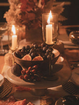 Orsina Cake Stand elegantly displaying fruits and decorative candles on a festive table setting