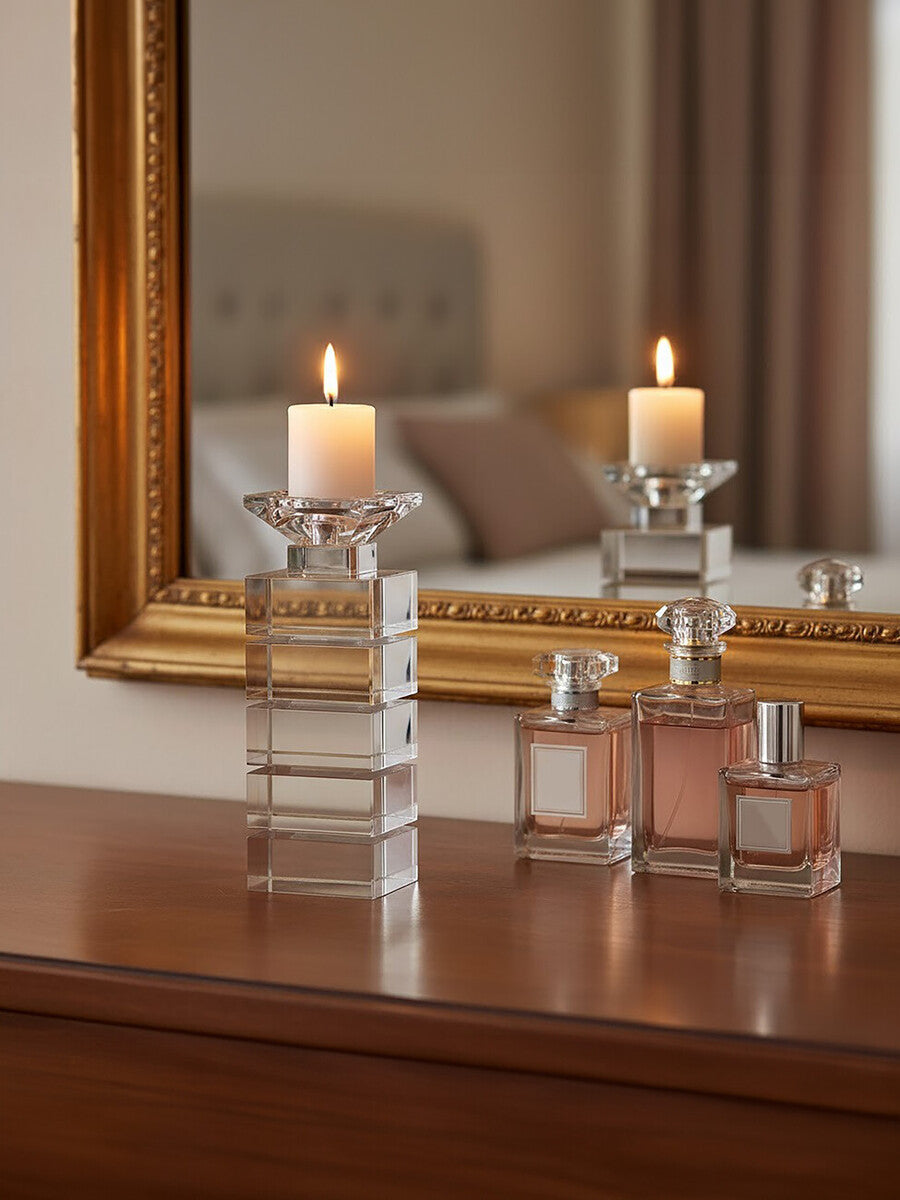 Orsina elegant glass Candle Holder with lit candle, placed beside decorative perfume bottles