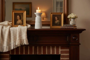 Elegant white Candle Holder on a rustic wooden mantel, surrounded by decorative frames and flowers