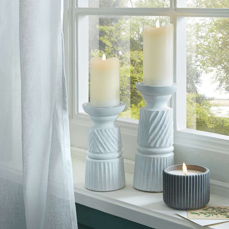 Elegant Shades 4 Seasons candle holder set featuring textured designs and warm candles by the window
