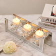 Elegant mirrored candle holder with four glass cups and lit candles, perfect for stylish decor