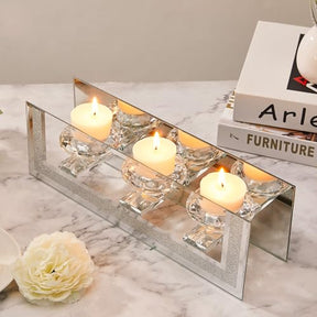 Elegant mirrored candle holder with four glass cups and lit candles, perfect for stylish decor