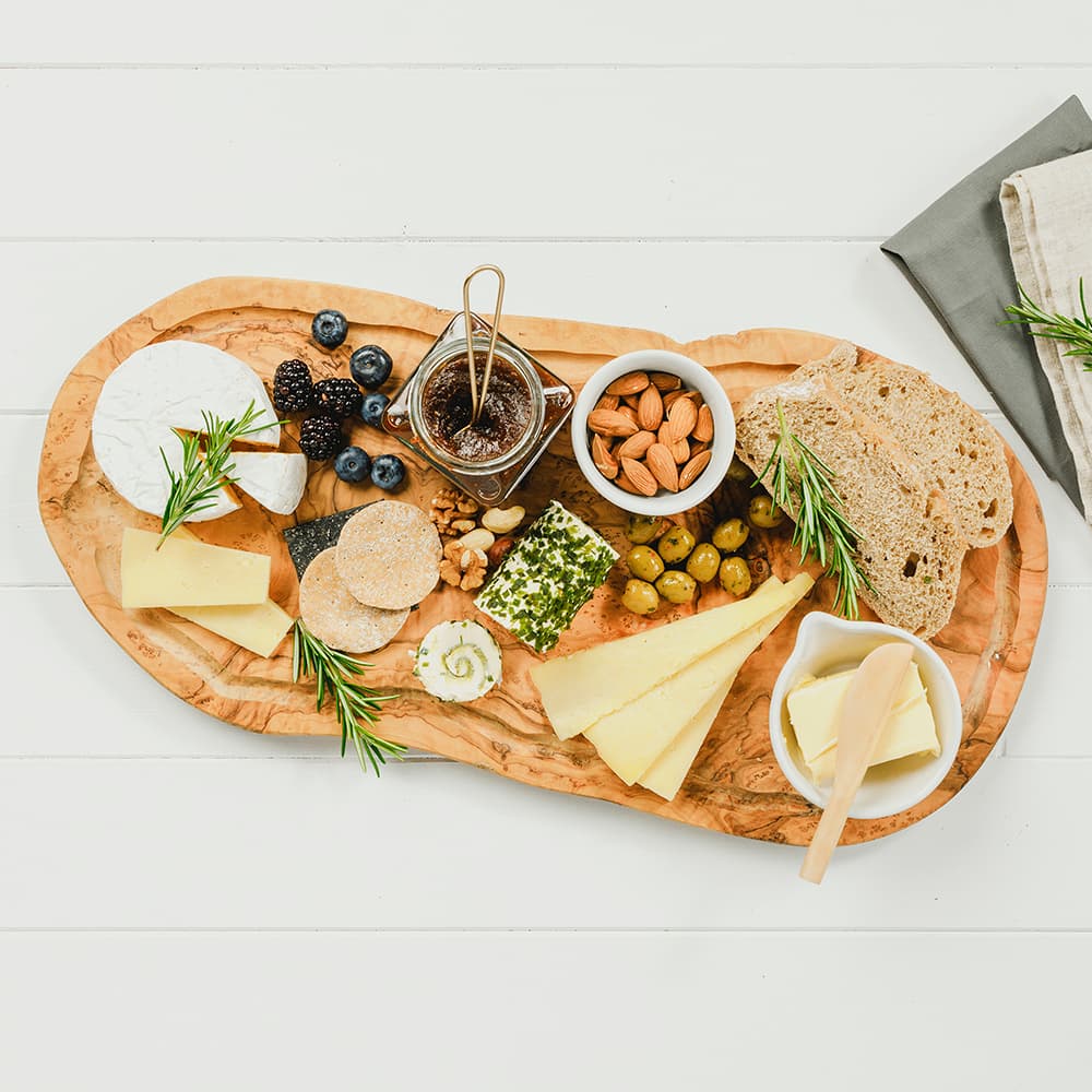 Selbrae House wooden carving board featuring an elegant cheese and charcuterie display
