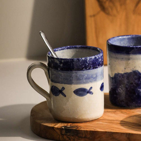 Selbrae House Ceramic Mug with Blue Fish Design on a Wooden Surface
