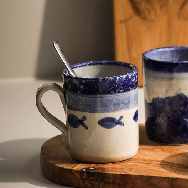 Selbrae House Ceramic Mug with Blue Fish Design on a Wooden Surface