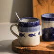 Selbrae House Ceramic Mug with Blue Fish Design on a Wooden Surface