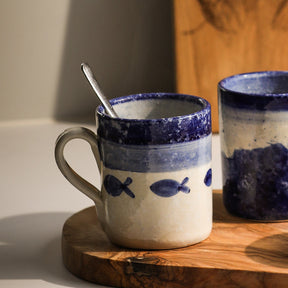 Selbrae House Ceramic Mug with Blue Fish Design on a Wooden Surface