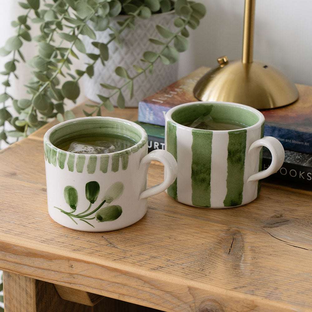 Selbrae House Ceramic Mug set featuring green botanical designs on a wooden table