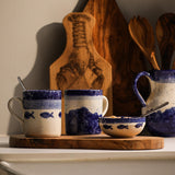 Set of Selbrae House ceramic mugs in blue and cream with wooden serving board and accessories