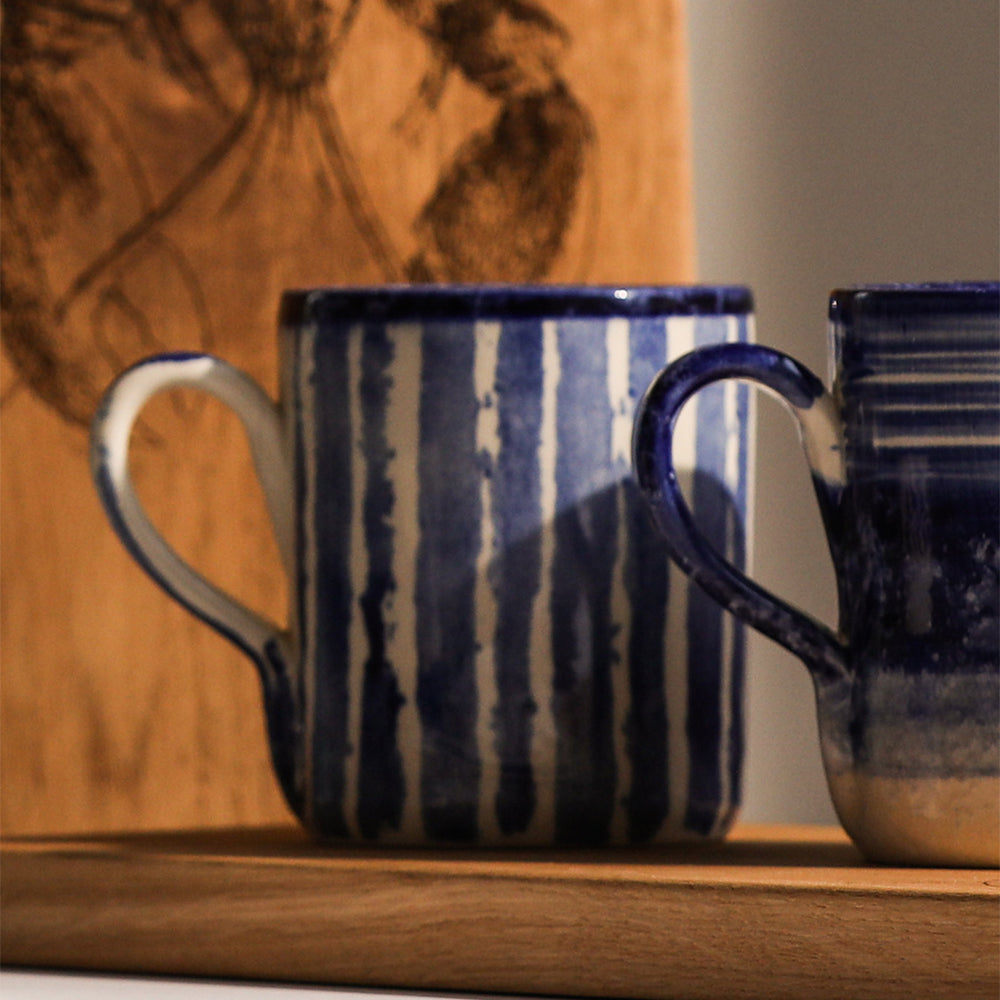 Two Selbrae House ceramic mugs with blue stripes, perfect for enjoying hot beverages
