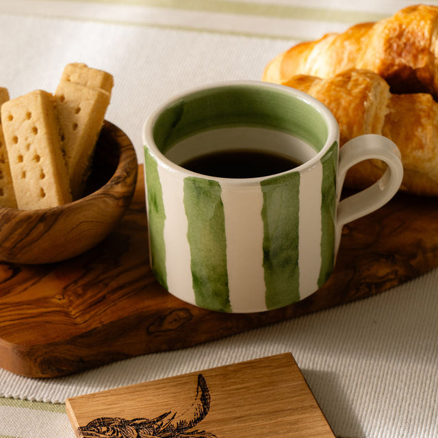 Selbrae House Ceramic Mug with Green Stripes, served with biscuits and croissants on a wooden platter