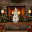 Ceramic Snowy Tree decoration on festive mantel with candles and greenery for Christmas room decor