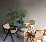 Stylish Nisu Home chairs in black and natural wood with woven seats, perfect for modern interiors
