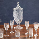 Elegant Orsina Champagne Flutes alongside a crystal beverage dispenser on a wooden table