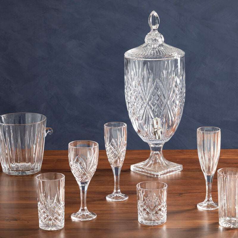 Elegant Orsina champagne glasses set on a wooden table with a crystal beverage dispenser