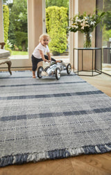Checkered Rug in blue tones with a child playing on it in a modern living space