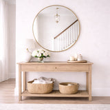 Elegant Circle Mirror above a wooden console table with decorative baskets and a vase of flowers