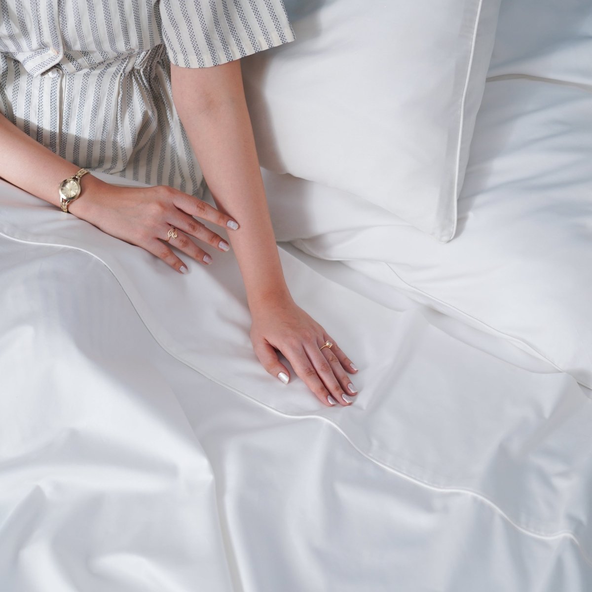 SHEET STORY Flat Sheet displayed on a bed with a stylish striped shirt and elegant bedding accessories
