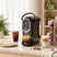 Wise Galleria Coffee Machine in black brewing espresso next to desserts and coffee cups