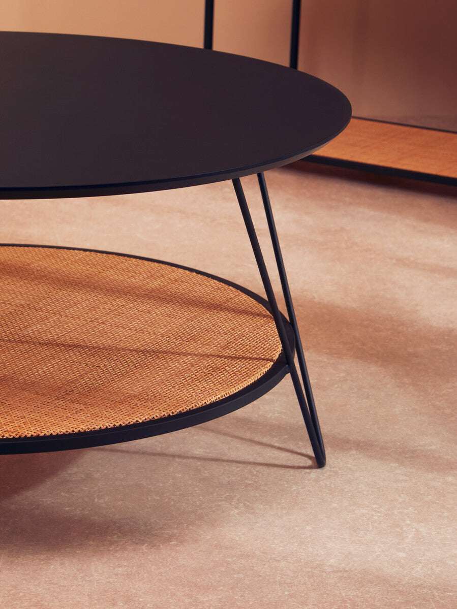 Orsina Coffee Table with a sleek black top and woven rattan shelf for stylish living room decor