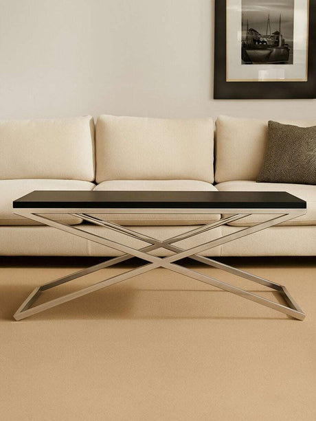 Orsina Coffee Table with a sleek black top and modern cross-base design in a stylish living room
