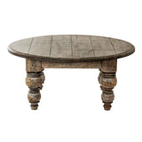 Rustic round coffee table with carved wooden legs and a weathered finish from Shades 4 Seasons