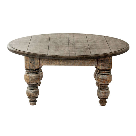 Rustic round coffee table with carved wooden legs and a weathered finish from Shades 4 Seasons