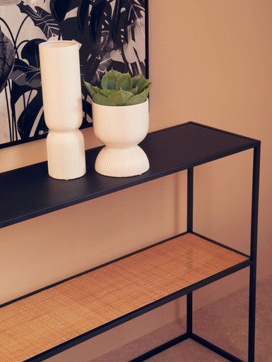 Orsina Console Table with Black Metal Frame and Woven Shelf, Styled with Decorative Vases and Green Plant