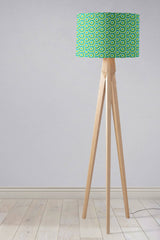 Stylish Shadow Bright lampshade with a vibrant green and blue geometric pattern on a wooden tripod lamp