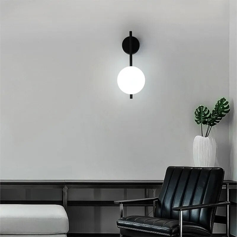 Modern wall lamp from Light My House featuring a round white globe and sleek black mount