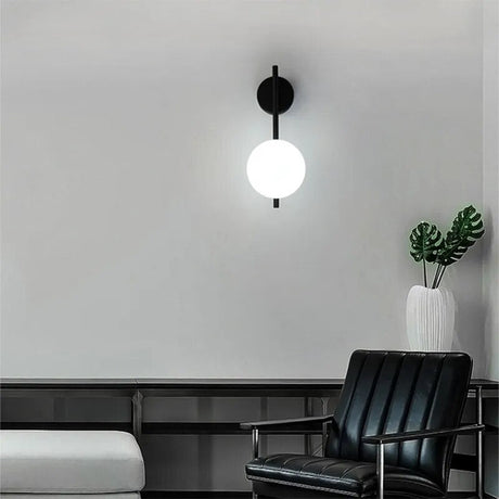 Modern wall lamp from Light My House featuring a round white globe and sleek black mount