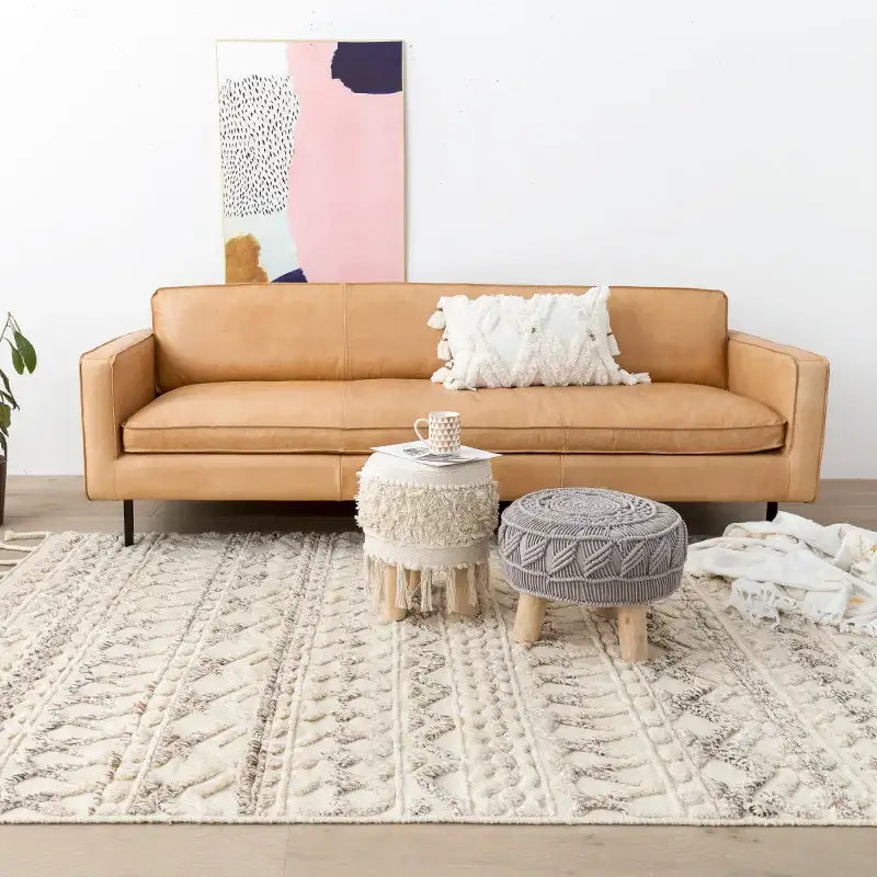 Nisu Home Cotton Rug in a stylish living room with a tan sofa and decorative stools