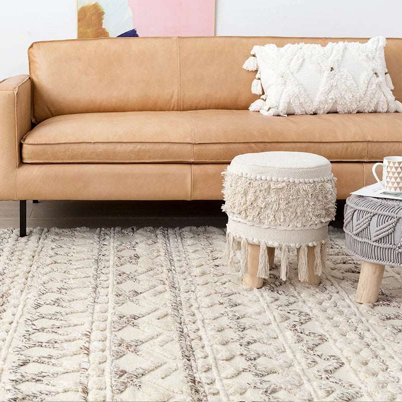 Nisu Home Cotton Rug in a stylish living room setting with a tan leather sofa and decorative pillows