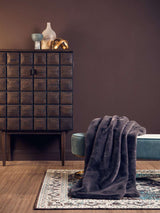 Orsina Fur Throw draped over a stylish bench in a modern interior setting