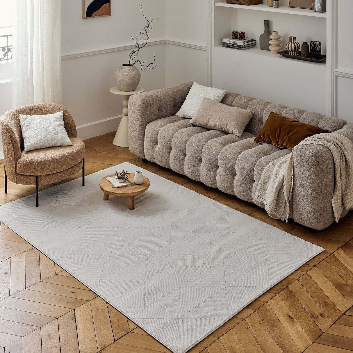 Stylish cream rug placed in a modern living room with a patterned sofa and minimal decor