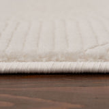 Close-up of a soft, textured cream rug with a subtle striped pattern