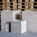 Four modern grey Cube Planters in various sizes for stylish indoor or outdoor planting