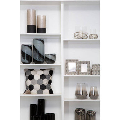 Orsina hexagonal patterned Cushion Cover displayed on a shelf with decorative vases and photo frames