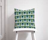 Geometric patterned cushion in green and blue on a white chair for stylish home decor