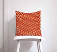 Shadow Bright Decorative Cushion with a vibrant red and orange circular pattern on a chair