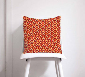 Shadow Bright Decorative Cushion with a vibrant red and orange circular pattern on a chair