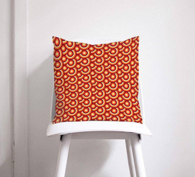Shadow Bright Decorative Cushion with a vibrant red and orange circular pattern on a chair