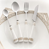 KitchBoom Cutlery Set featuring elegant white handles with gold detailing on a decorative plate