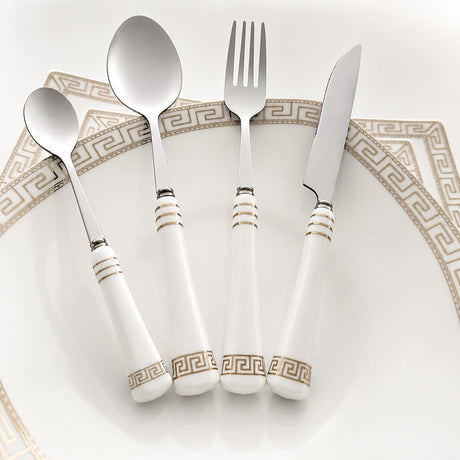 KitchBoom Cutlery Set featuring elegant white handles with gold detailing on a decorative plate