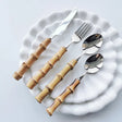 Nisu Home Cutlery Set with Bamboo Handles on White Plates for Elegant Dining