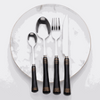 KitchBoom Cutlery Set in elegant black with gold accents on a marble plate