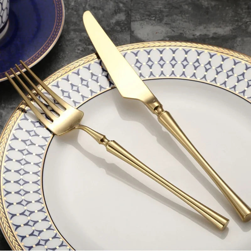 Elegant gold cutlery set including a fork and knife on a decorative plate