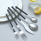 Nisu Home Cutlery Set featuring sleek black handles and polished stainless steel for modern dining